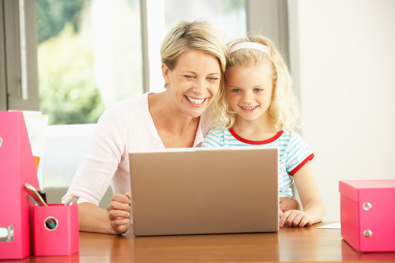 mom on laptop with young girl child